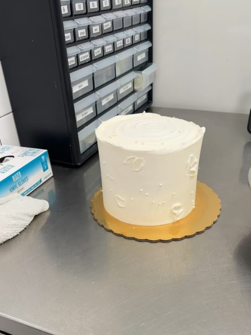 Simple white textured cake on a gold board