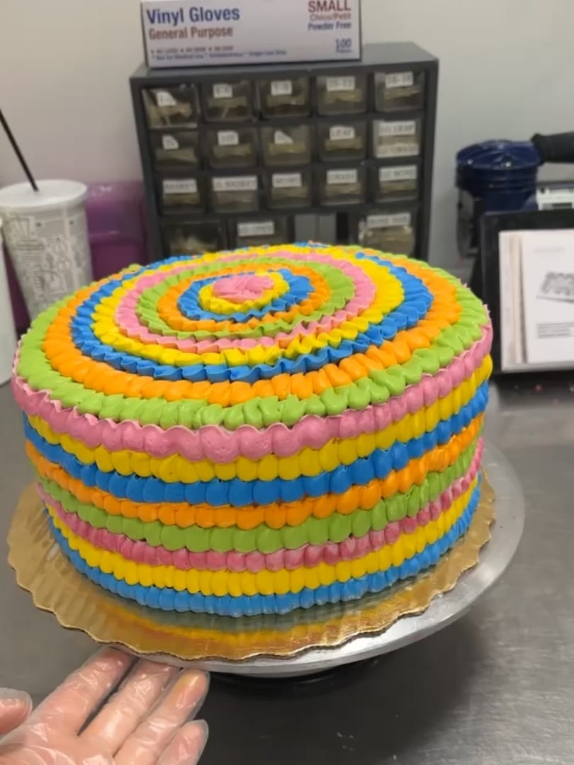 Round cake with rainbow-colored concentric rings of buttercream