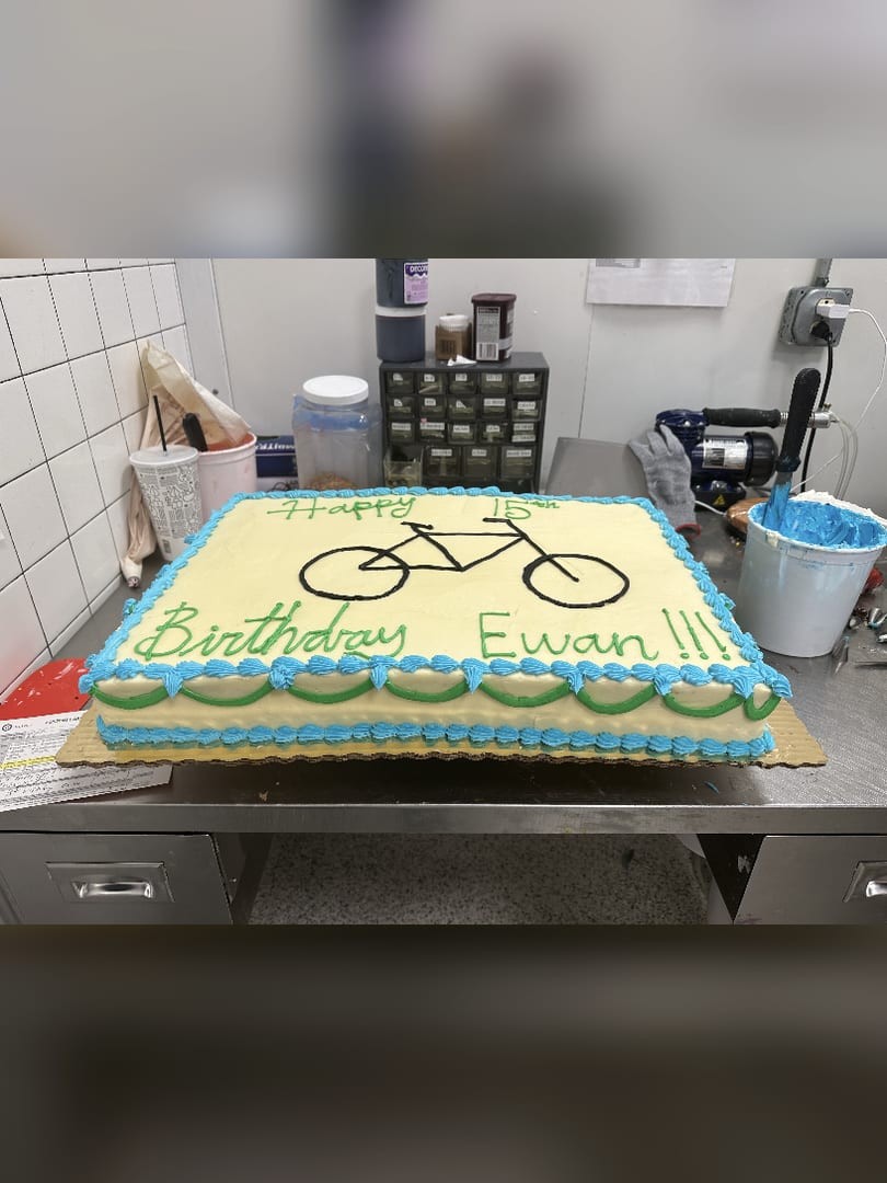 Sheet cake with a tandem bicycle design and a birthday message